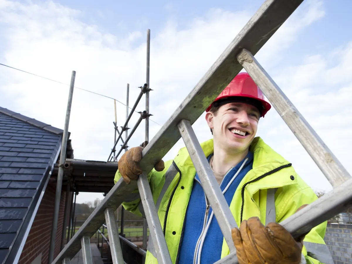 Roofer laying new tiles on a pitched roof